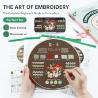 Someone embroiders a brown fabric with mushrooms, flowers, and colourful patterns using the Embroidery Stitch Practice Kit 7. Nearby are scissors, threads, and guides. Text: The Art of Embroidery: The Complete Beginner’s Guide to Embroidery.