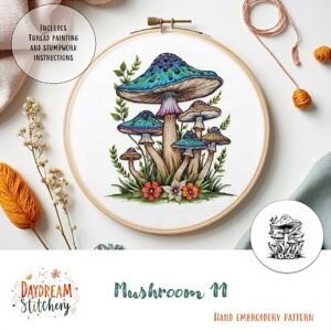 The Mushroom 11: Hand embroidery pattern showcases a vibrant cluster of blue-capped mushrooms surrounded by flowers and leaves, with threads and tools artfully arranged on a light surface.