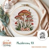 The Mushroom 13: Hand embroidery pattern is displayed in a wooden hoop, featuring detailed mushrooms, greenery, and flowers. Includes thread painting and stumpwork instructions. Text reads: Mushroom 13: Hand embroidery pattern.