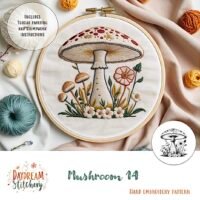 A vibrant Mushroom 14: Hand embroidery pattern features large and small mushrooms, flowers, and greenery. Surrounded by threads, it’s designed by Daydream Stitchery.
