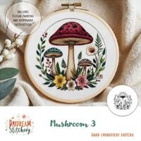 The Mushroom 3a: Hand embroidery pattern features three colourful mushrooms with flowers and leaves, plus thread painting and stumpwork instructions. Text on the hoop reads “Mushroom 3a” and “Hand embroidery pattern.”.